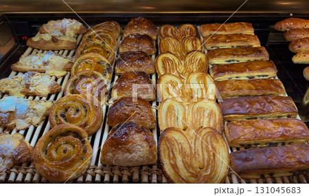 Various French pastries and croissants, freshly baked and arranged in rows Various French pastries and croissants, freshly baked and arranged in rows 131045683