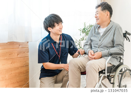 車椅子のシニア男性患者と介護士・ケアマネージャーの男性スタッフ（認知症・リハビリ） 131047035