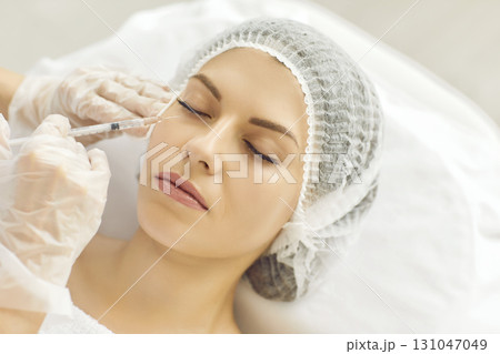 Young woman receiving professional under eye filler injection at aesthetic clinic 131047049