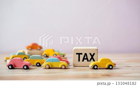 A toy car next to a wooden block displaying the word tax, symbolizing tax day preparations and financial planning 131048182