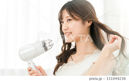 ヘアドライヤーでヘアブロー・髪の毛を乾かす女性(ヘアケア) ヘアドライヤーでヘアブロー・髪の毛を乾かす女性(ヘアケア) 131049236