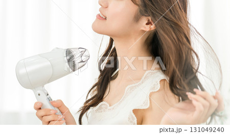 ヘアドライヤーでヘアブロー・髪の毛を乾かす女性（ヘアケア） 131049240
