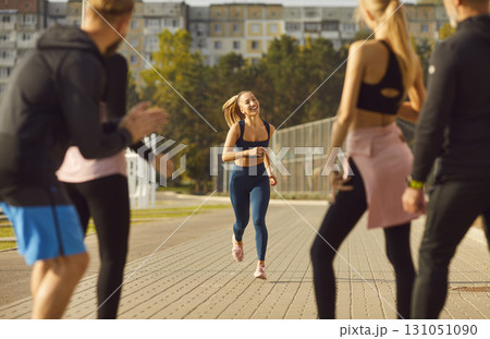 Running, friends waiting for female athlete, happy diverse people sharing sport success, training Running, friends waiting for female athlete, happy diverse people sharing sport success, training 131051090