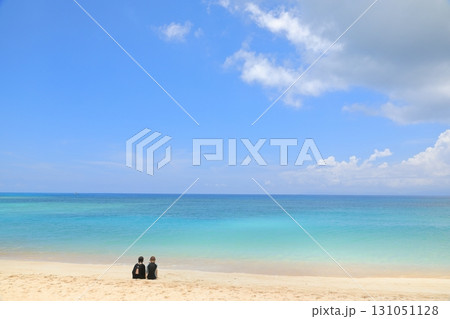 波照間島ニシ浜の白砂の砂浜に座って海を眺める人たち 131051128