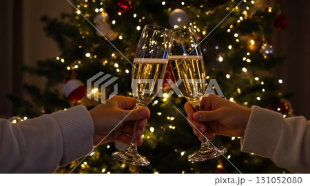 クリスマスツリーとイルミネーションを背景にシャンパングラスが一列に並び、乾杯と祝賀ムードを漂わせる華 131052080