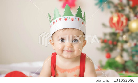 クリスマスの紙製の王冠の帽子をかぶった生後8ヶ月の赤ちゃんの肖像画 131052086