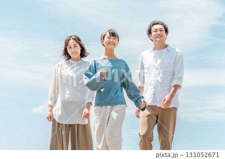 青空の下を歩く,散歩する3人の親子（家族旅行,ファミリー,父親,母親,娘） 131052671