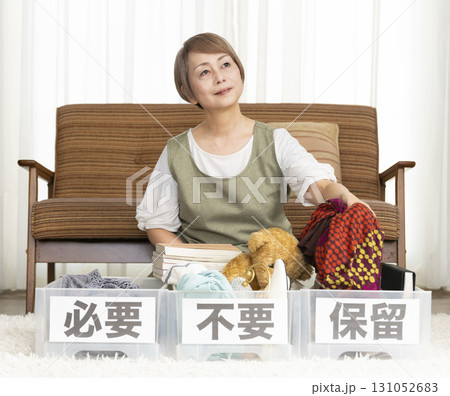 リビングで断捨離をするシニア女性 リビングで断捨離をするシニア女性 131052683