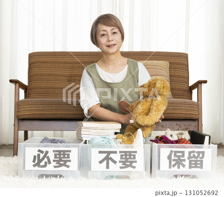 リビングで断捨離をするシニア女性 リビングで断捨離をするシニア女性 131052692