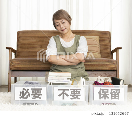 リビングで断捨離をするシニア女性 リビングで断捨離をするシニア女性 131052697