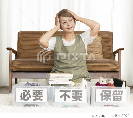 リビングで断捨離をするシニア女性 リビングで断捨離をするシニア女性 131052704