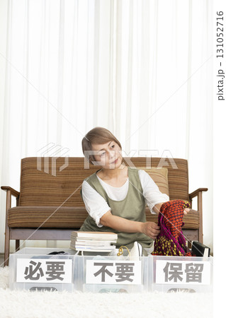 リビングで断捨離をするシニア女性 リビングで断捨離をするシニア女性 131052716