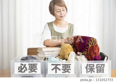 リビングで断捨離をするシニア女性 リビングで断捨離をするシニア女性 131052733