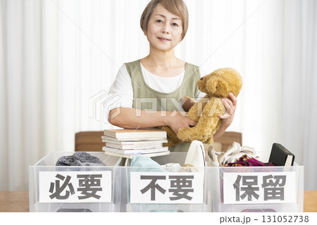 リビングで断捨離をするシニア女性 リビングで断捨離をするシニア女性 131052738