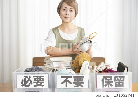 リビングで断捨離をするシニア女性 リビングで断捨離をするシニア女性 131052741