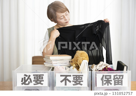 リビングで断捨離をするシニア女性 リビングで断捨離をするシニア女性 131052757