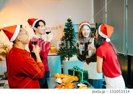 Asian friends capture the holiday spirit with gifts, laughter, and a festive Christmas dinner in a cozy, joy-filled setting 131053314