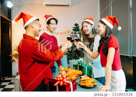 Asian friends capture the holiday spirit with gifts, laughter, and a festive Christmas dinner in a cozy, joy-filled setting Asian friends capture the holiday spirit with gifts, laughter, and a festive Christmas dinner in a cozy, joy-filled setting 131053316