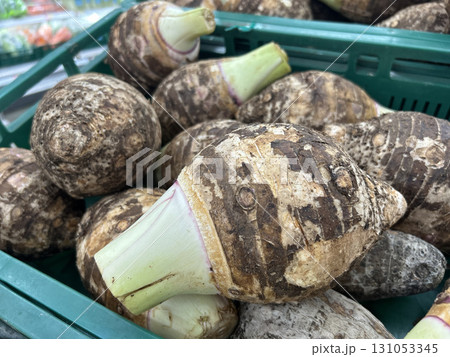 Fresh taro roots piled high in a green market crate Fresh taro roots piled high in a green market crate 131053345