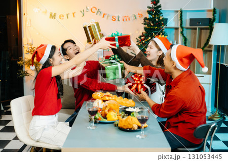 Holiday spirit with Asian friends exchanging gifts, sharing laughs, and enjoying a festive Christmas 131053445