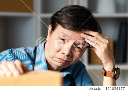 Entrepreneur reflecting on challenges while managing online business operations with packages. 131054177
