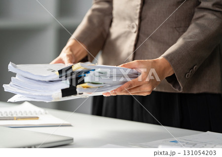 Business professional organizing important documents for a meeting. 131054203
