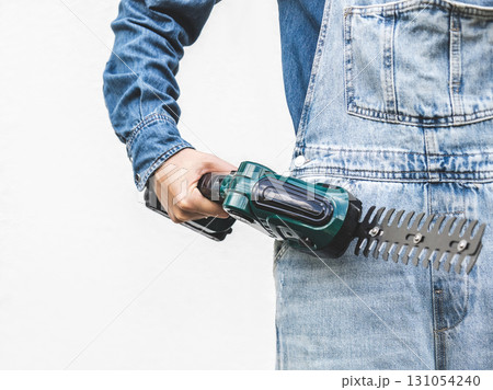 Cute woman, work clothes and hedge trimmer. Studio shot. Cute woman, work clothes and hedge trimmer. Studio shot. 131054240