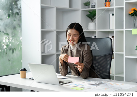 Business professional analyzing financial data and discussing strategies in a modern office setting. Business professional analyzing financial data and discussing strategies in a modern office setting. 131054271