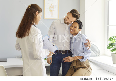 Smiling couple meeting a female doctor in bright modern medical clinic today Smiling couple meeting a female doctor in bright modern medical clinic today 131056257
