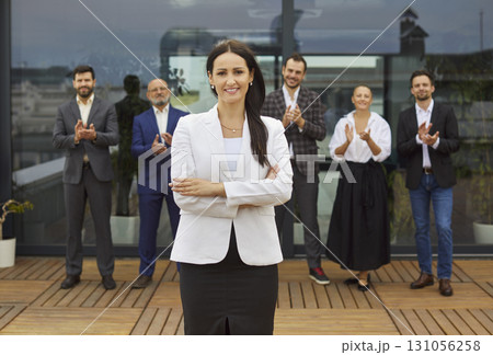 Smiling female business leader receives applause from diverse professional team Smiling female business leader receives applause from diverse professional team 131056258