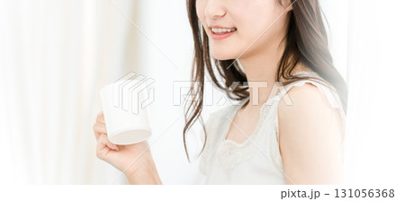 朝、家で白湯・コーヒー・ホットドリンク・カフェオレ・カフェラテを飲む笑顔のアジア人女性 朝、家で白湯・コーヒー・ホットドリンク・カフェオレ・カフェラテを飲む笑顔のアジア人女性 131056368