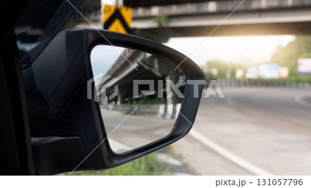 Mirror view from the side of the car can see the bridge and the road. Light shot straight into the middle of the asphalt road. Road curves along the side of the route. 131057796