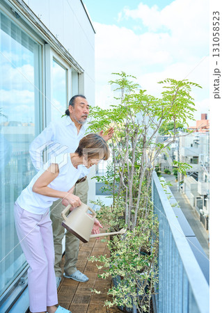 ベランダで観葉植物に水をあげる熟年夫婦　資産家 131058523