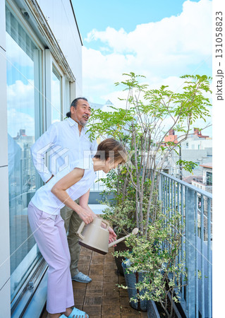 ベランダで観葉植物に水をあげる熟年夫婦 資産家 ベランダで観葉植物に水をあげる熟年夫婦 資産家 131058823