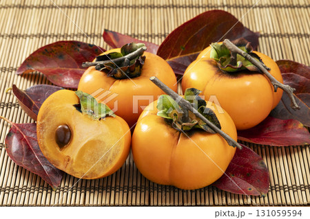 赤く色づいた葉を添えた秋の果物柿 131059594