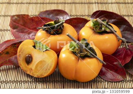 赤く色づいた葉を添えた秋の果物柿 131059599