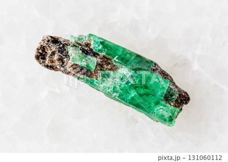 sample of raw emerald crystal on white marble sample of raw emerald crystal on white marble 131060112