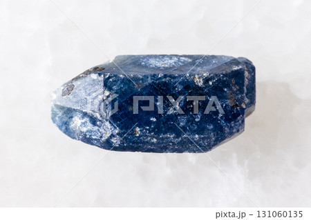 rough single blue sapphire crystal on white 131060135