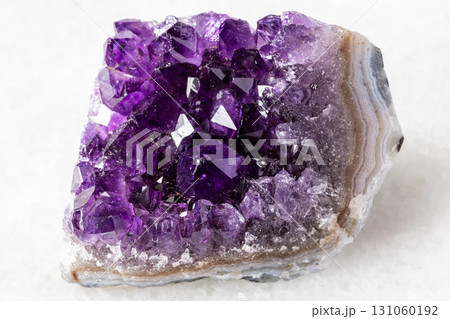 raw geode of amethyst mineral crystals on white 131060192