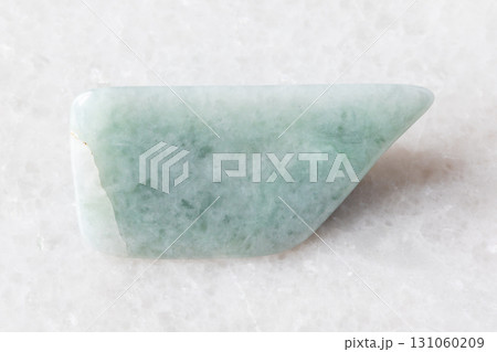 sample of polished jadeite mineral on white marble sample of polished jadeite mineral on white marble 131060209
