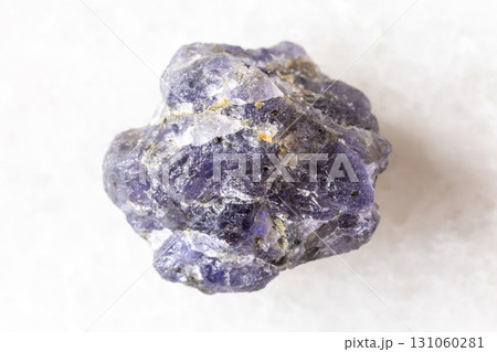 sample of raw iolite mineral on white marble 131060281