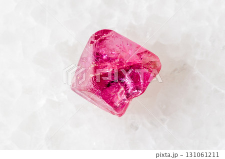 sample of raw pink spinel mineral on white marble 131061211