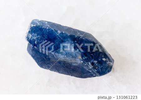 raw single blue sapphire crystal on white marble 131061223