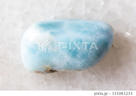 sample of tumbled larimar mineral on white marble 131061233
