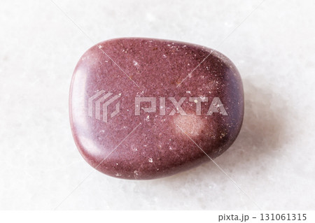 polished red brown quartzite rock on white marble polished red brown quartzite rock on white marble 131061315