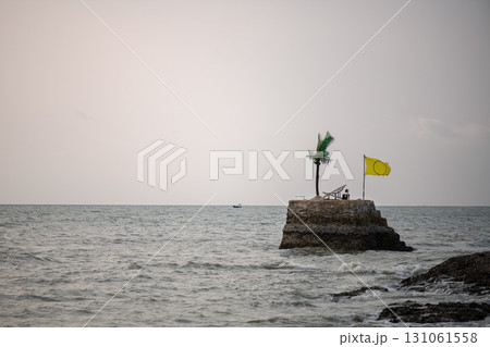 An isolated island with a beach bed, a yellow flag and a single coconut tree, An isolated island with a beach bed, a yellow flag and a single coconut tree, 131061558