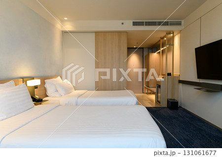 A double bed covered with white sheds in a beautiful bedroom. A double bed covered with white sheds in a beautiful bedroom. 131061677