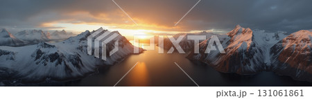 A beautiful northern landscape at sunset, with snow-covered mountains and a lake. 131061861