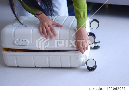 Young women packing luggage for holiday trip. 131062021