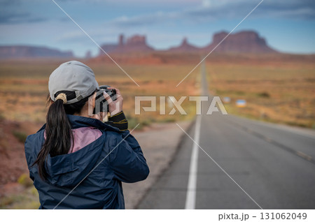 Asian female tourist taking photo of a popular shot at Forrest Gump Point, view of monument valley 131062049